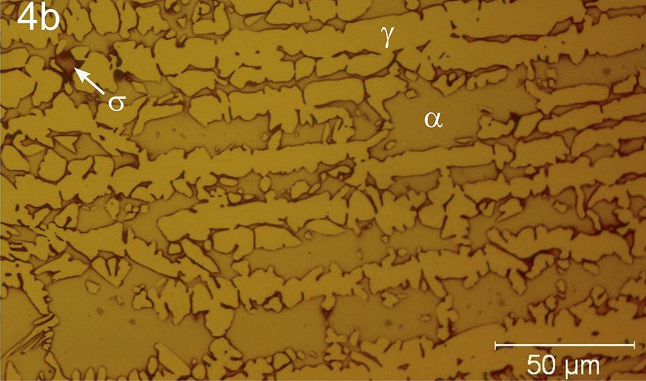 Polished and etched microstructure of sintered stainless steel MIM material showing grain structure and residual porosity